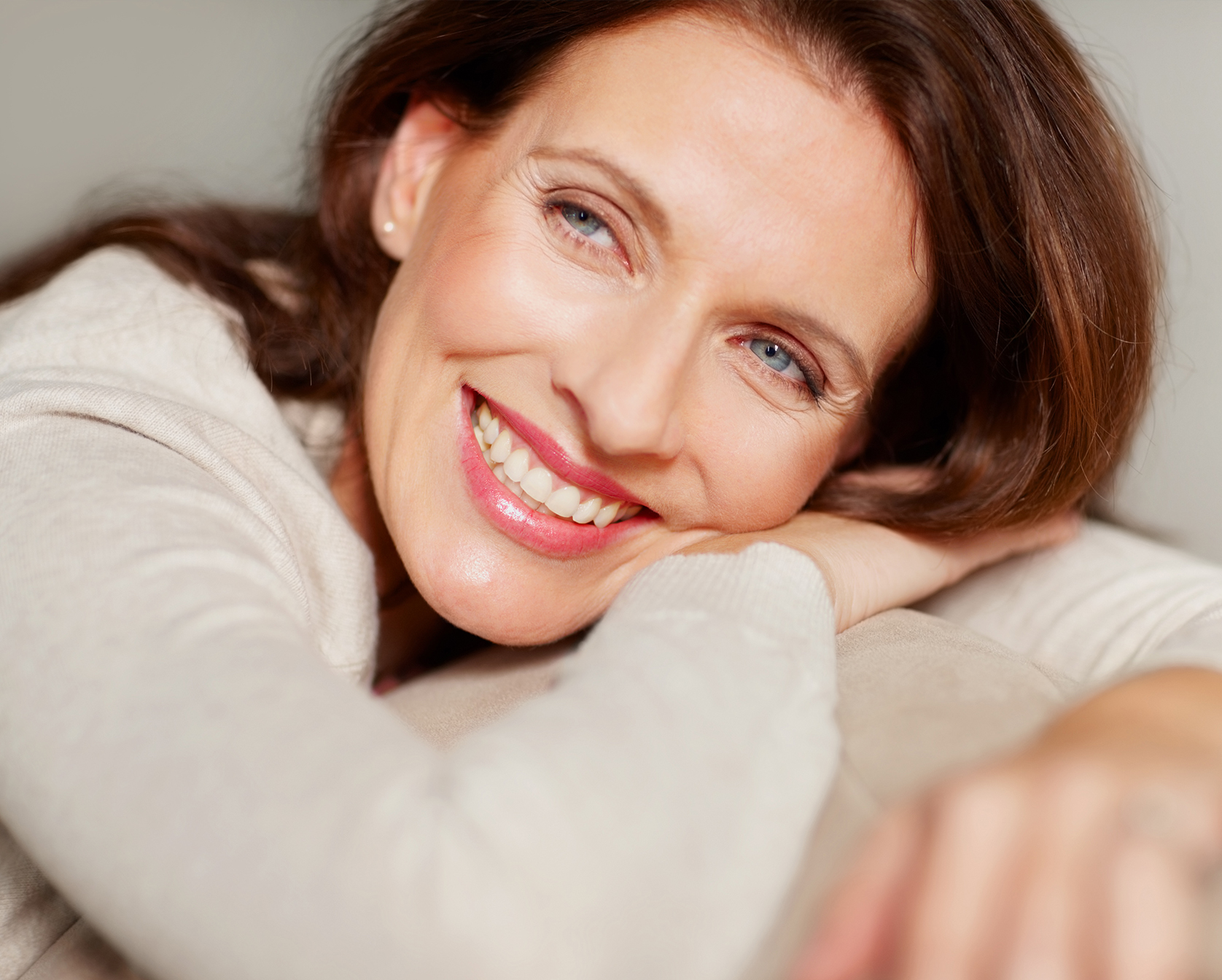Woman laying on couch smiling