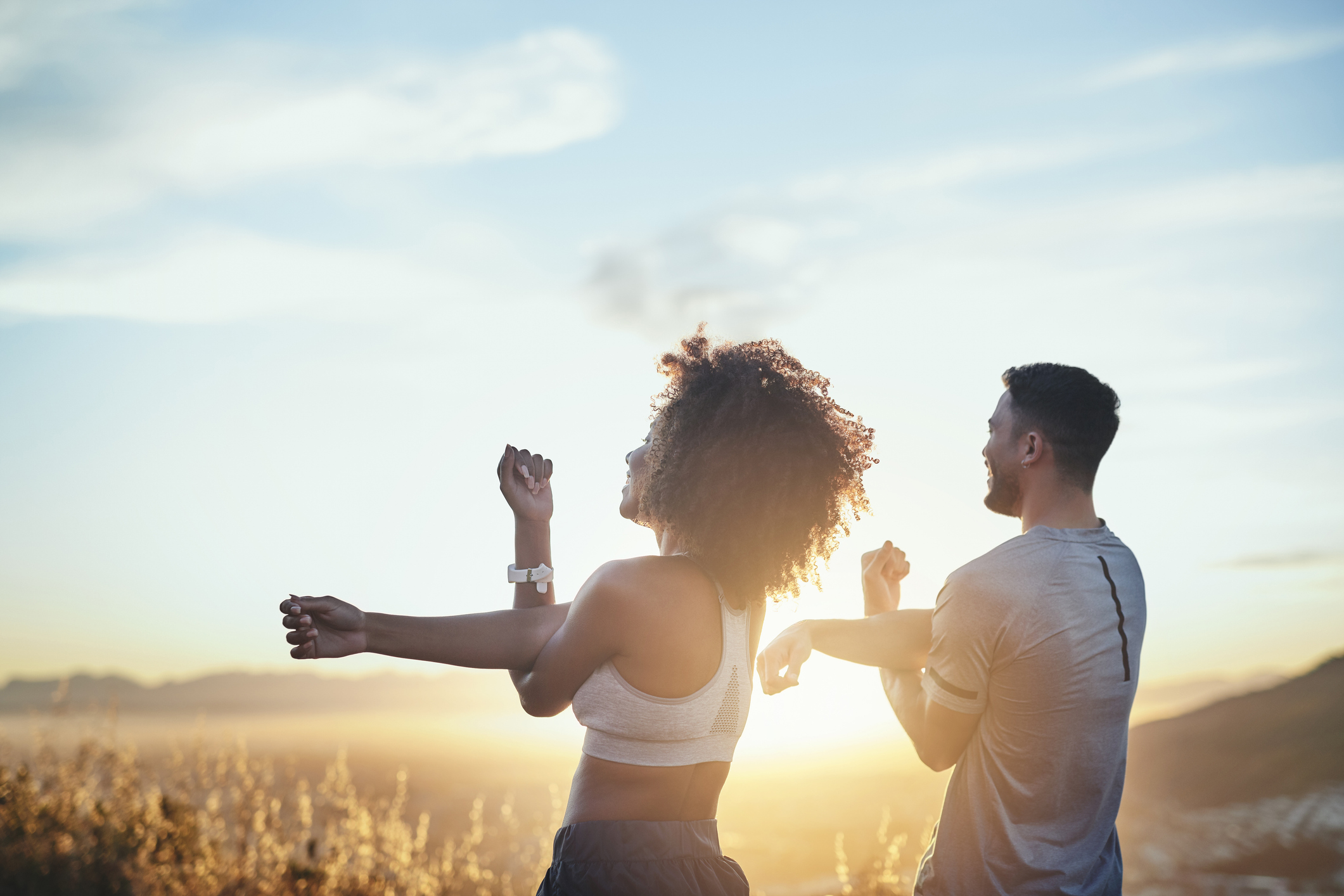 man and a woman stretching their arms